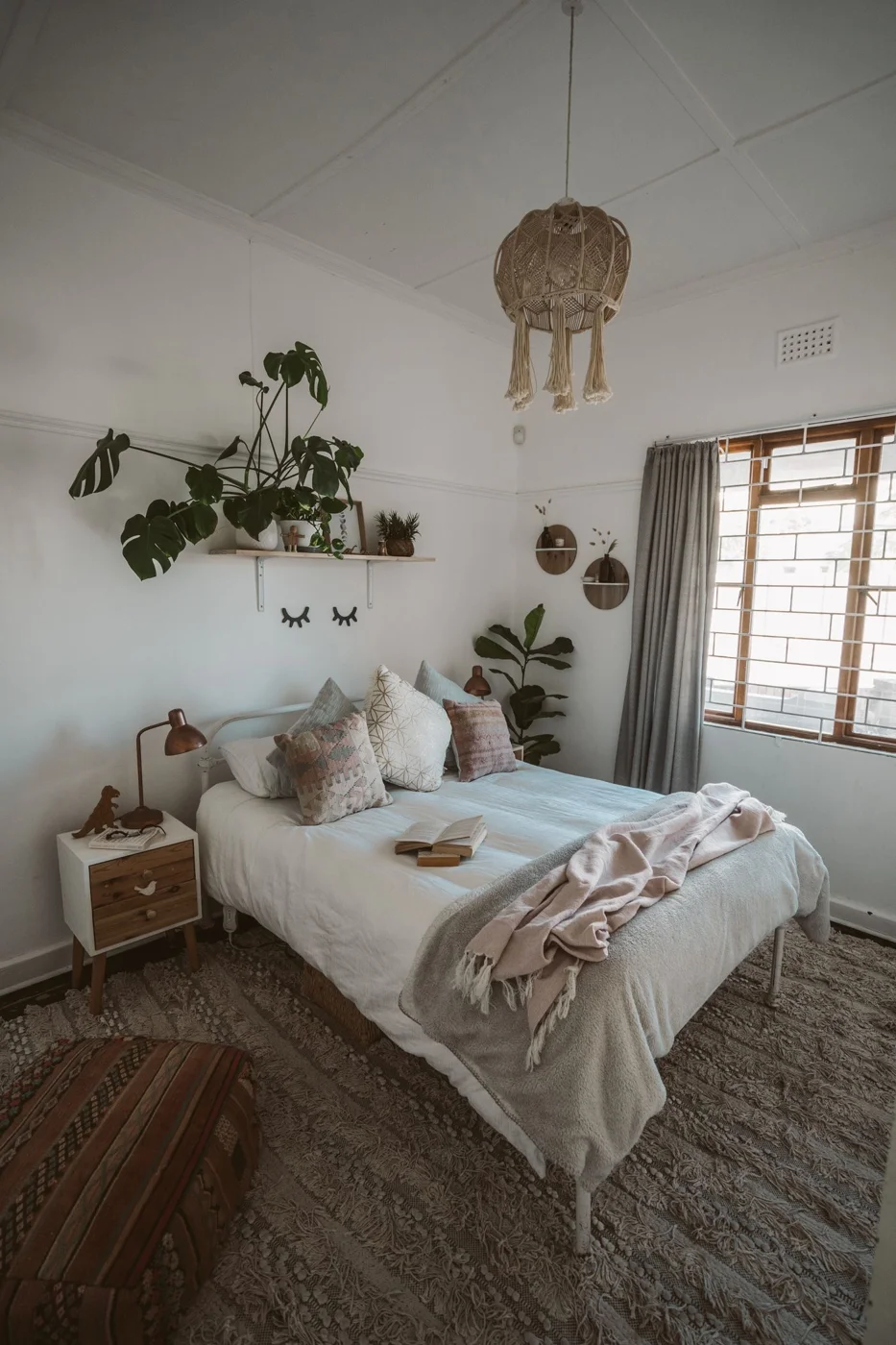 A bed with white linen in a softly lit bedroom