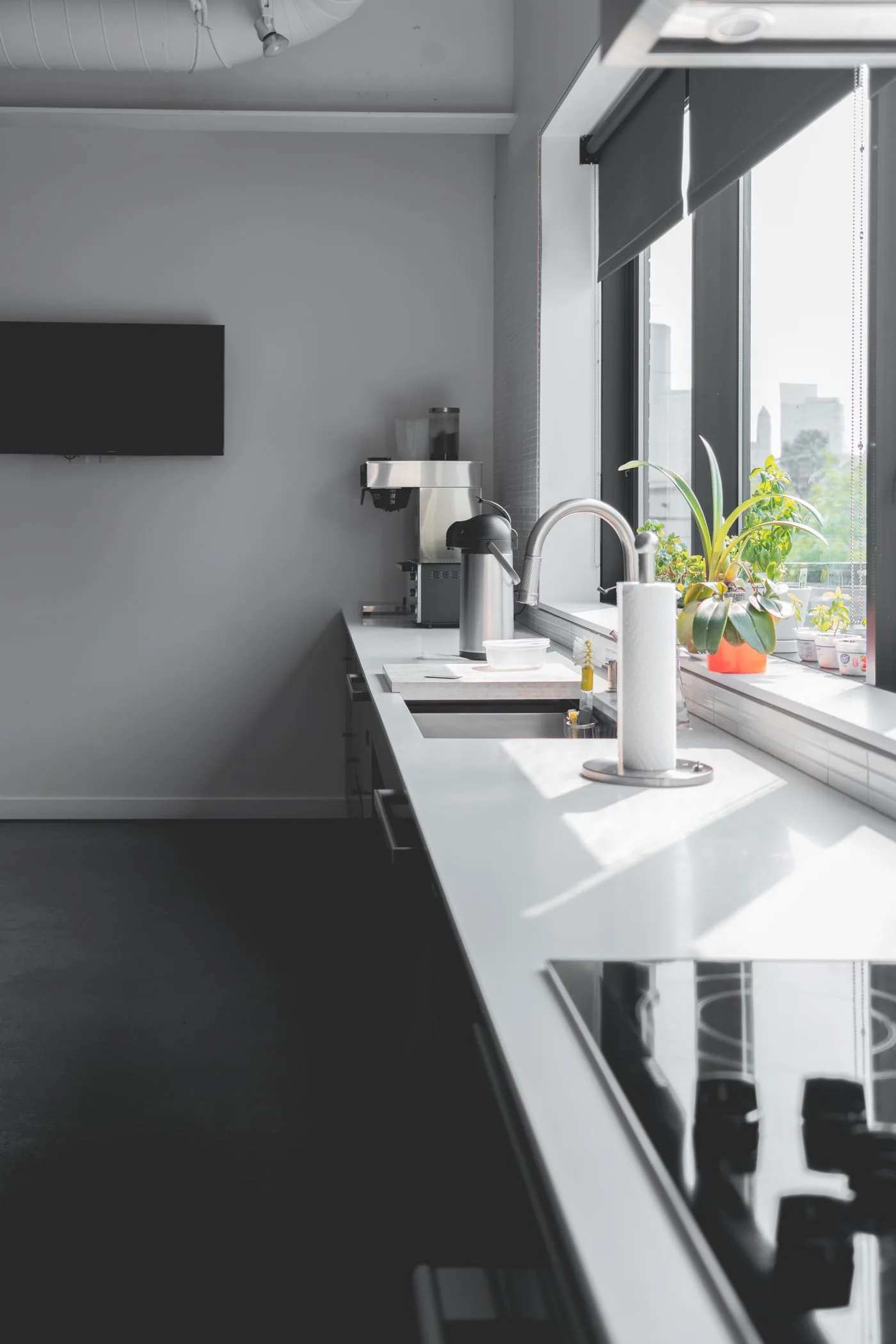 Sleek modern kitchen design featuring a sunlit countertop and large windows for a bright interior.