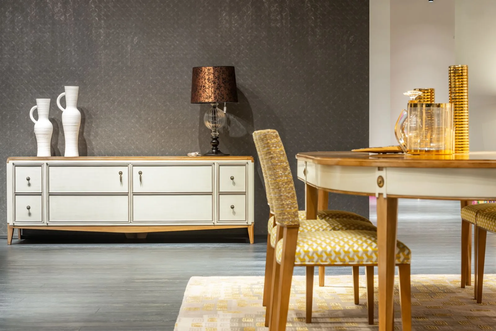 A dining area with an upholstered chair, table and pale sideboard