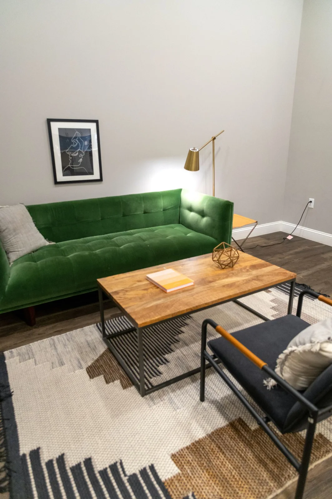 Living room with green sofa and wooden furniture