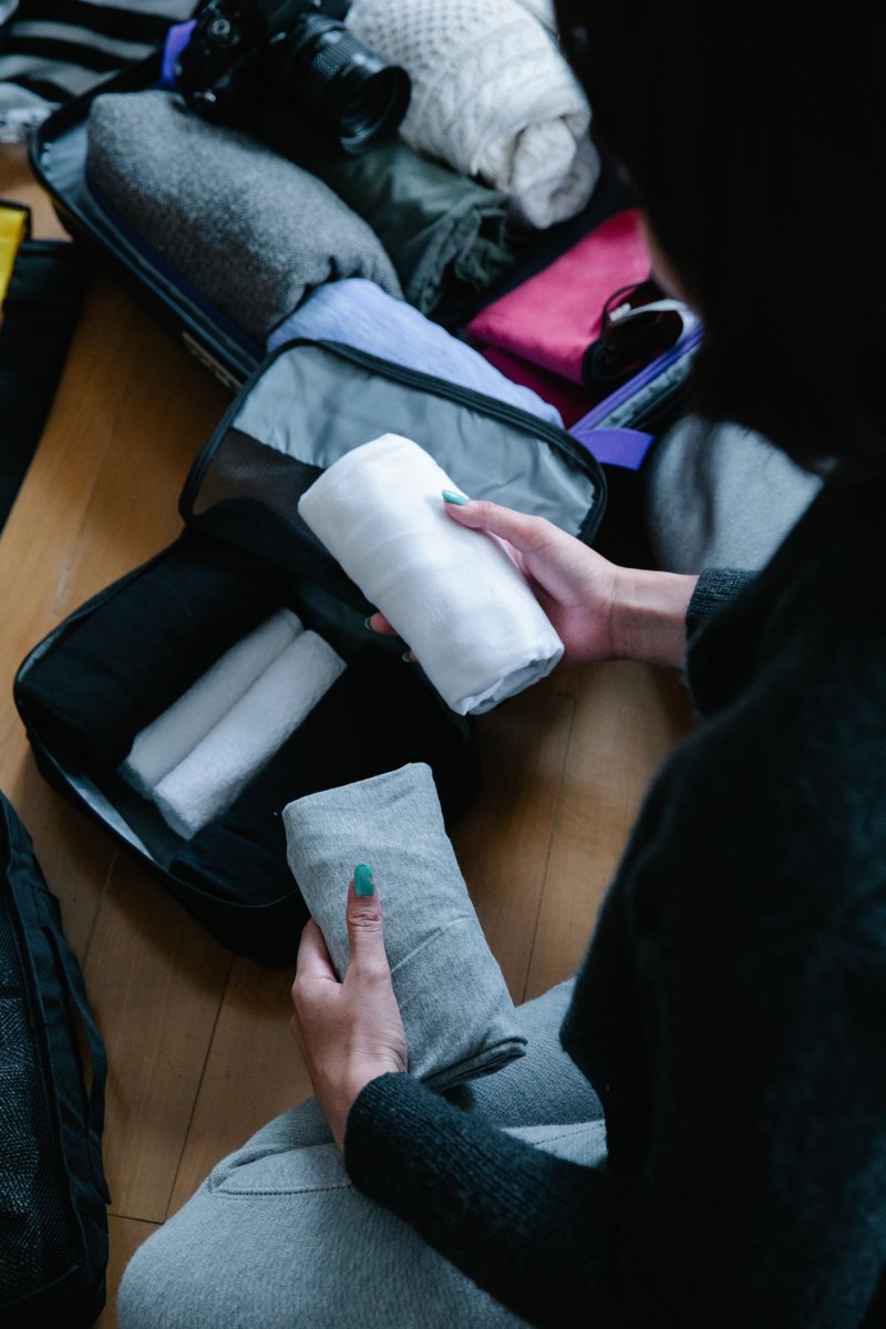 Folded clothing being organised for travel in a suitcase
