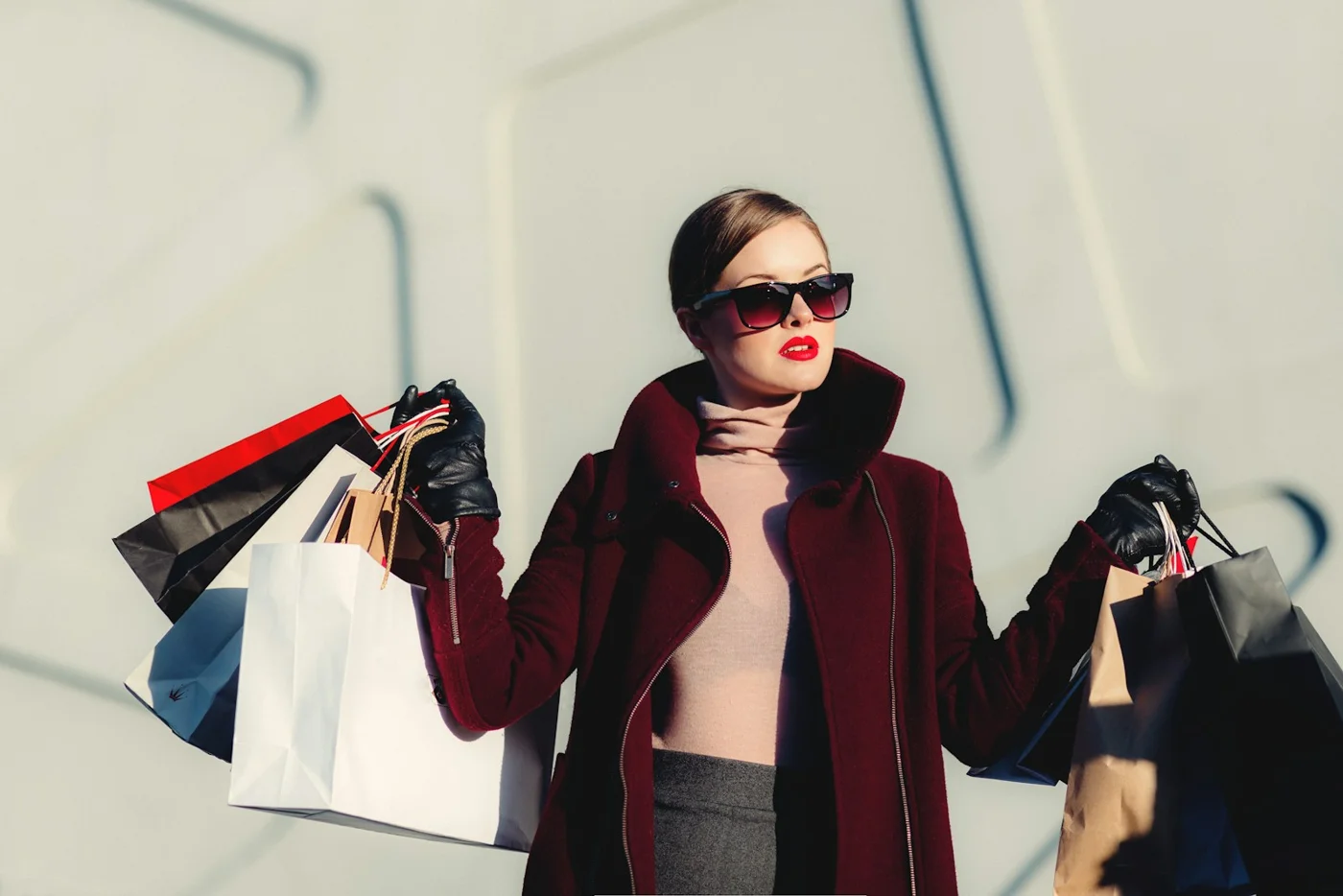 A woman in sunglasses carrying shopping bags
